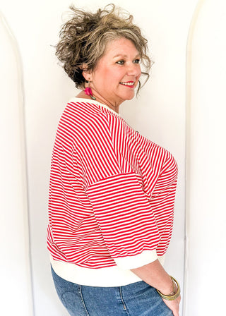 Striped knit dolman top with crew neckline and ribbed trim in red.