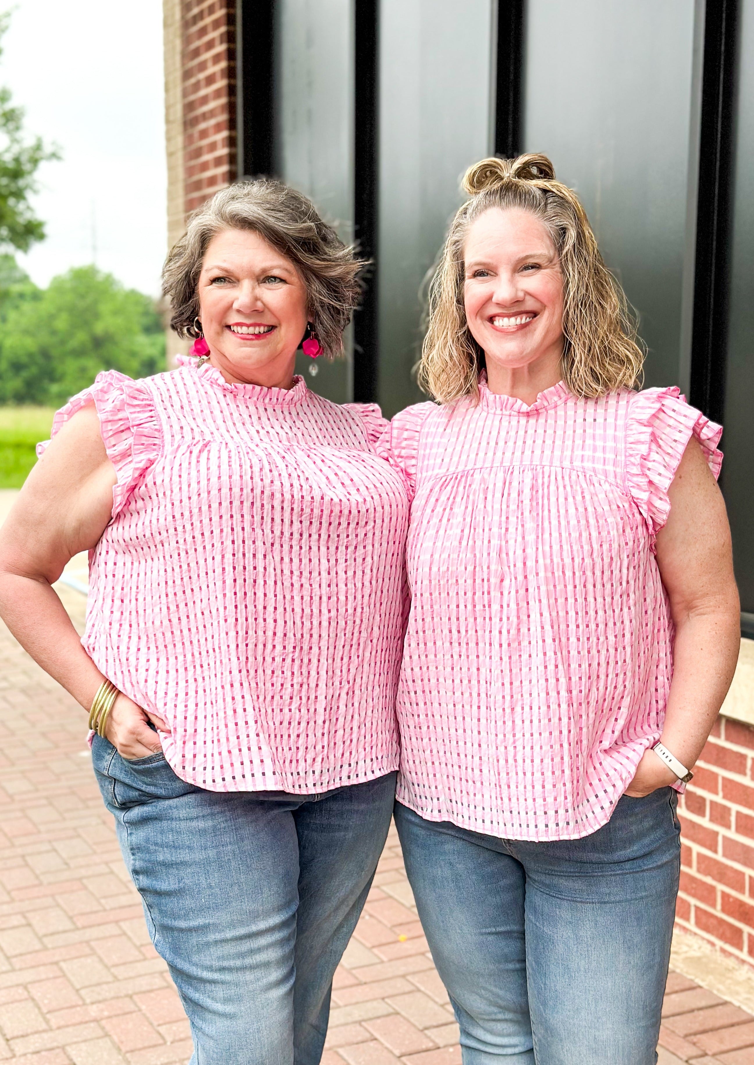 Pink seersucker ruffle sleeve top with ruffle neck and hint of white throughout - top is lined
