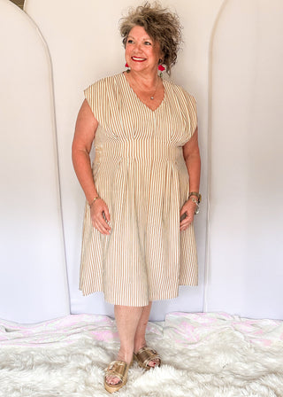 Sleeveless dress with vertical taupe and white stripes. v neck and smocked waist