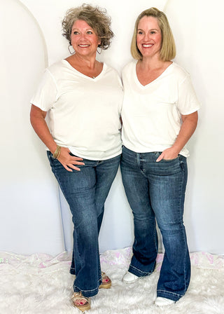 two women wearing denim trouser jeans and white tee.