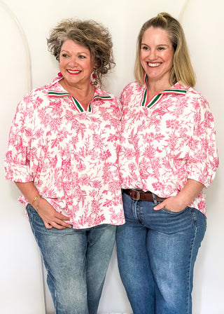 White top with pink floral pattern and v-neckline with contrast trim