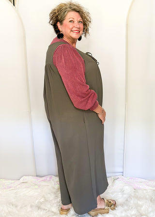 Charcoal gray sleeveless woven jumpsuit with ribbon tie neckline, pockets, and flowy wide-leg fit.
