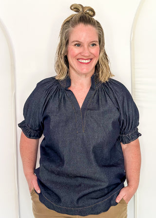 Women's indigo denim-look blouse featuring a smocked split neckline, puff sleeves, and a relaxed fit.