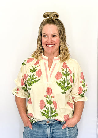 3/4 smocked sleeve cream top with large pink blooms. V-neck with pink trim detail. 