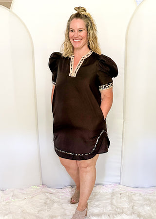 Black puff sleeve knee length dress.  Leopard piping detail on sleeves, v-neck, and at the bottom of the dress. Short sleeve.