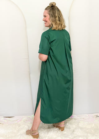Woman wearing short sleeve, collared, Hunter Green midi dress with decorative gold snaps.