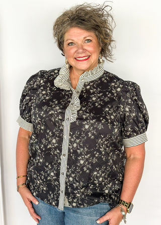 Black with small white florals-short sleeve button up top. Black and white stripe ruffle collar and sleeve binding.  