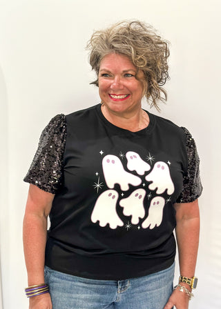 Black short sleeve top with sequin sleeves. Multiple white ghosts on the front