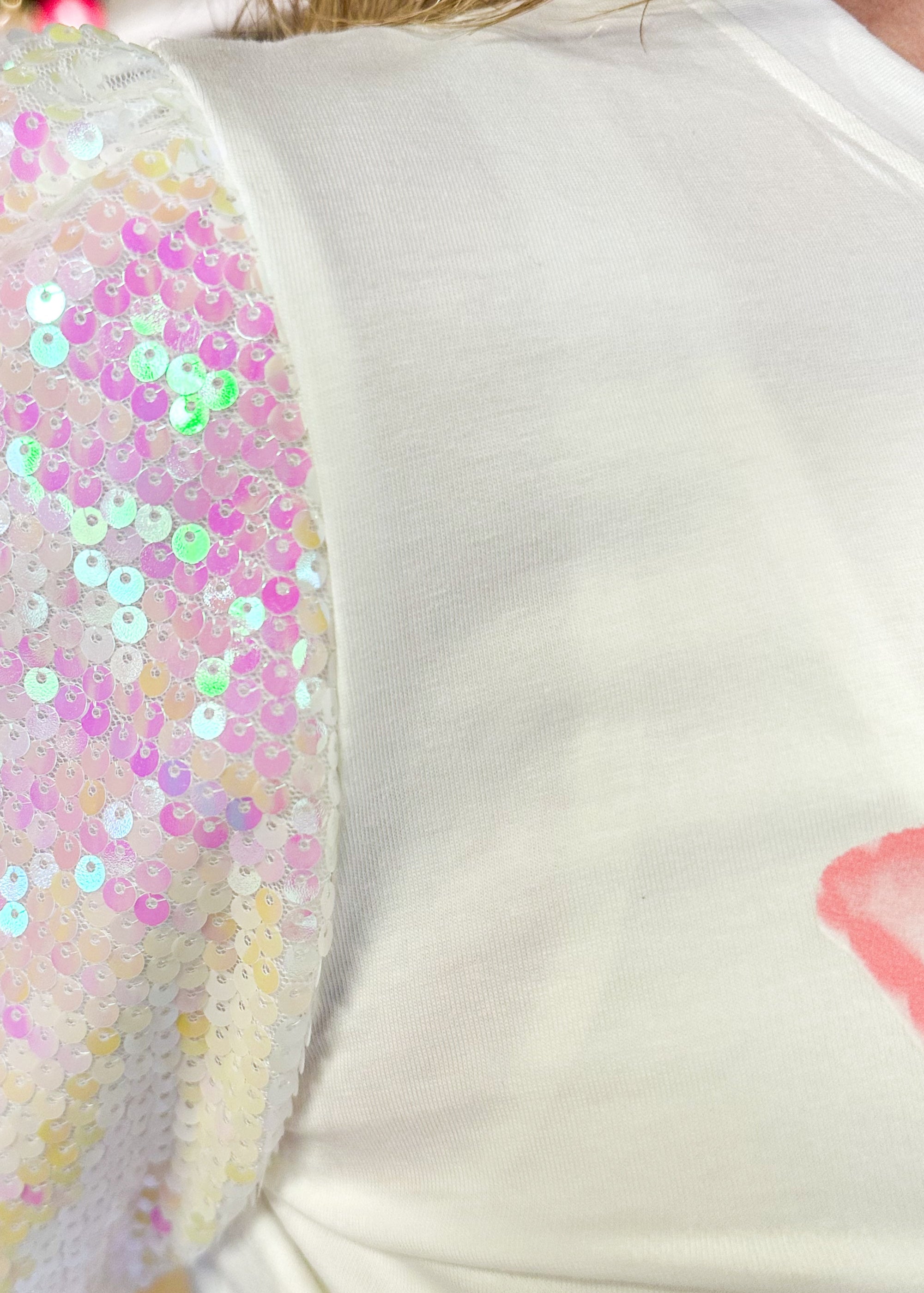 white short sequin sleeve top with XOXO in a light pink on the front - iridescent sequins on sleeves