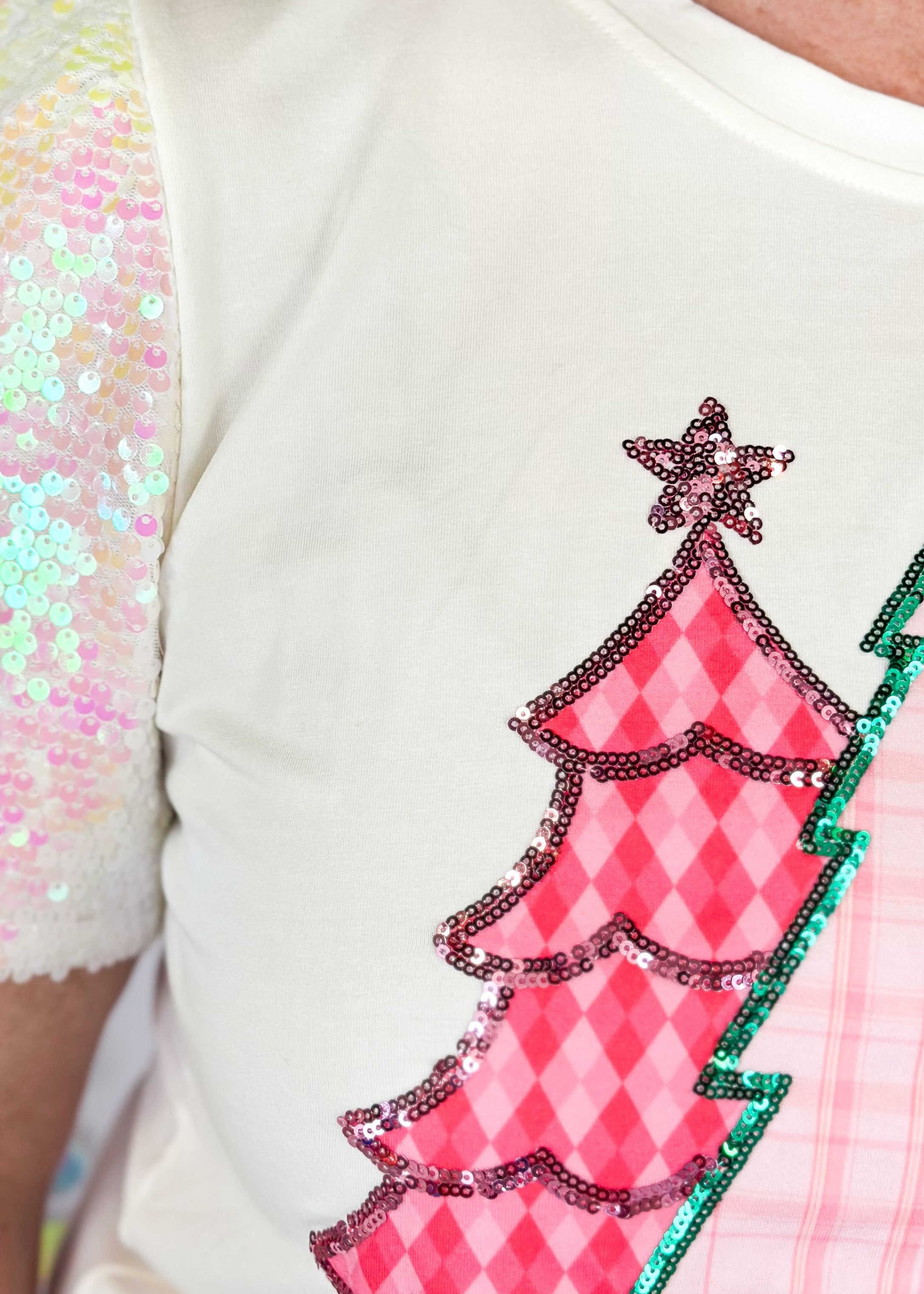 white short sleeve top with iridescent sequin sleeves, round neck, sparkly trio of trees patch on the front