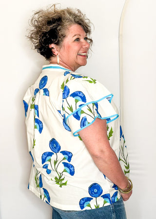 white top with oversized blue flower pattern and short sleeves