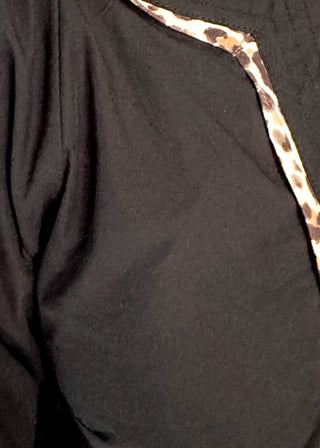 Black long-sleeve blouse with leopard print trim on split neckline and cuffs.