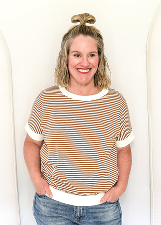 Woman wearing a striped shirt and jeans against a white background