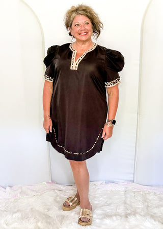 Black puff sleeve knee length dress.  Leopard piping detail on sleeves, v-neck, and at the bottom of the dress. Short sleeve.