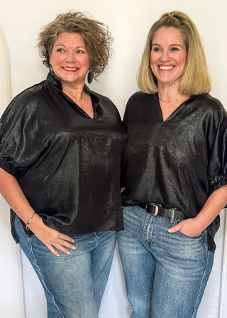 Shimmer black V-neck blouse with relaxed elastic short sleeves and a split hem at waist. 