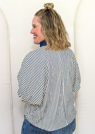 Model wearing an indigo-colored Entro dolman striped top with contrast trim, styled in a relaxed, casual fit.