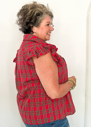 side view of woman wearing red plaid shirt with flutter sleeves