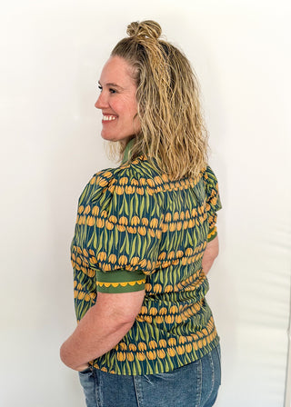 Large puff sleeve top with golden tulips and green leaves.  Contrast is green with yellow scallop detail-short sleeve and v-neck.
