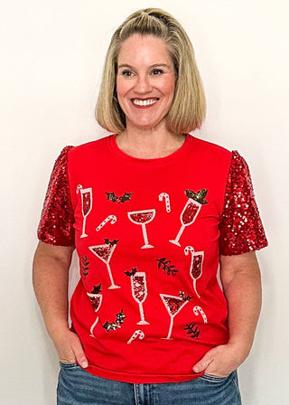 woman modeling a short sleeve red sequin sleeve top with sequin drinks on the front. 