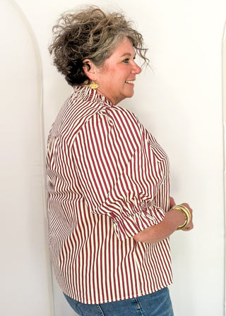woman profile wearing a striped short sleeve top and jeans. 