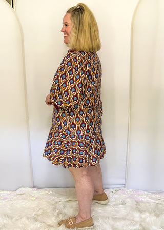 Wine-colored geometric print dress with collared neckline, tiered hem, and 3/4 sleeves.
