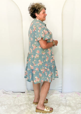 side view of woman wearing button front denim dresses with pink floral design.  