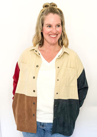 Colorblock corduroy shacket with front and side pockets. featuring cream, camel, forest green, and dark red panels, long sleeves, and snap-front closure