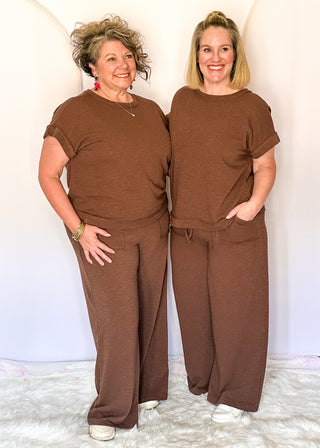 brown two-piece lounge set with relaxed short sleeve top and wide-leg drawstring pants.