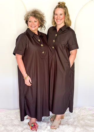 Casual black women’s dress with collared neckline, rolled sleeves, and decorative gold snaps