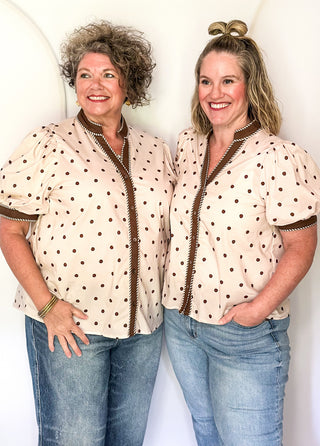 two women wearing Ecru button up top with brown polka dots. 