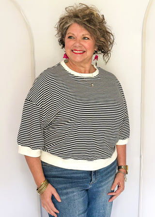 Striped knit dolman top with crew neckline and ribbed trim in black.