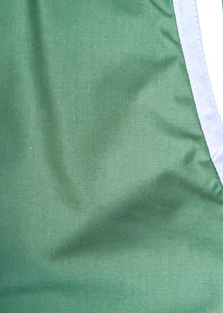 Close-up of a green fabric surface with a light blue and white vertical stripe detail along the right side.