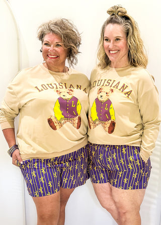 Tan long sleeve pull over with "LOUISIANA" in curved bold font above Benny the Bear in his Louisiana purple and gold letter jacket.  