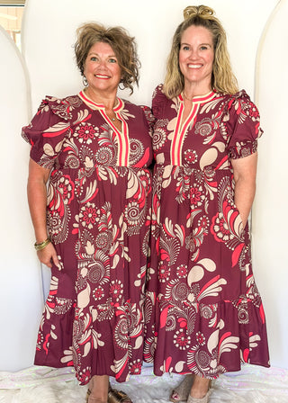 Plum floral maxi dress with short sleeves and v-neck. Collar has contrast piping in light brown and coral. 