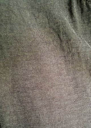 Close up of solid black textured blouse with a V-notch neckline, short sleeves