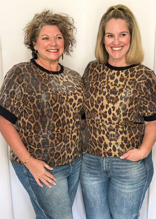 Animal print sequin shirt featuring short sleeves and black contrast trim on the neckline and sleeves.