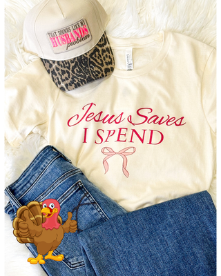 White t-shirt with 'Jesus Saves I Spend' text, blue jeans, and a cap with text on a white background