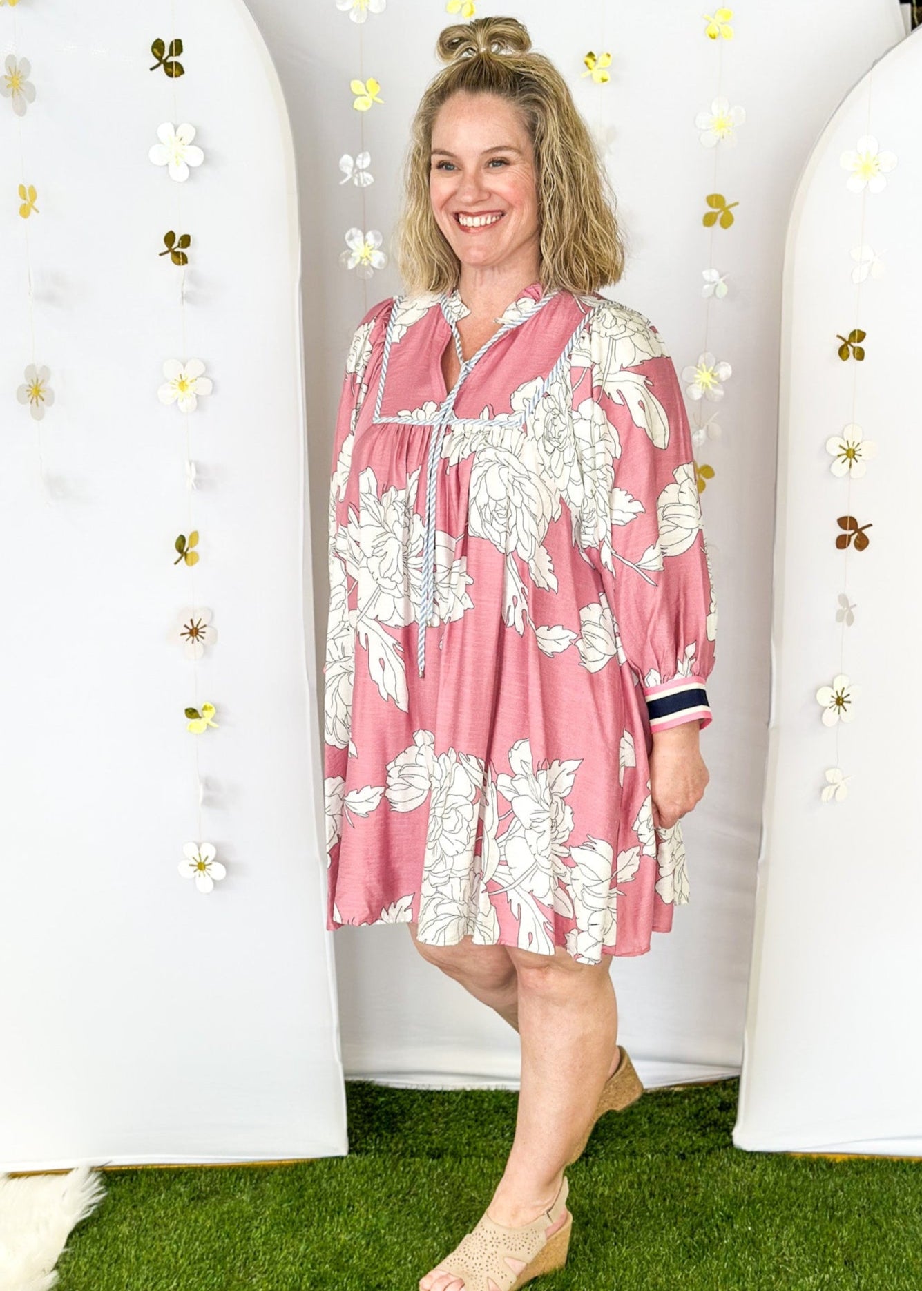 Pink Dress with large cream flowers.  Tie front collar with 3/4 oversized balloon sleeve- contrasting color stripe on the sleeve, lined with pockets. 