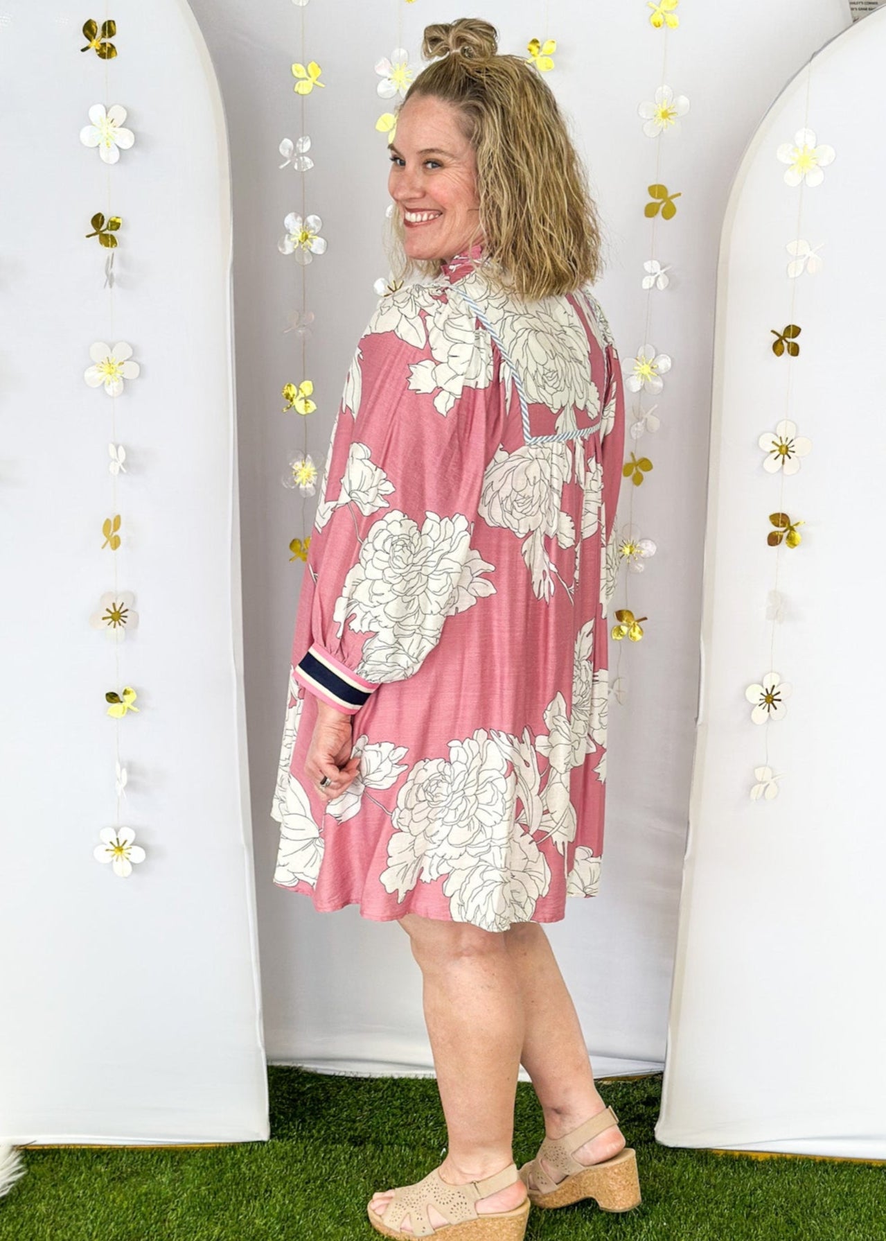 Pink Dress with large cream flowers.  Tie front collar with 3/4 oversized balloon sleeve- contrasting color stripe on the sleeve, lined with pockets. 