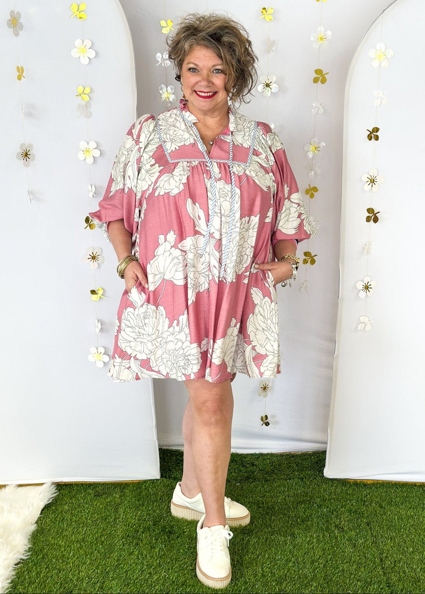 Pink Dress with large cream flowers.  Tie front collar with 3/4 oversized balloon sleeve- contrasting color stripe on the sleeve, lined with pockets. 