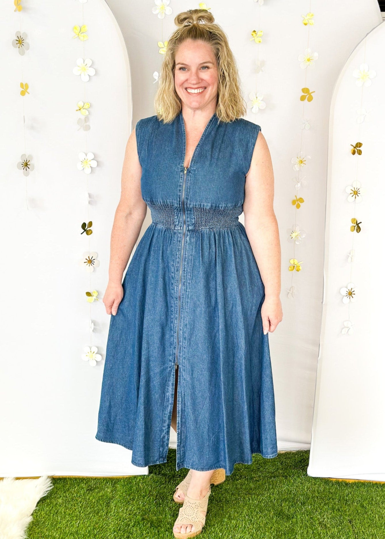 Sleeveless denim v-neck midi dress with cinched waist and pockets. Zipper closure down the front ending in a slit.  