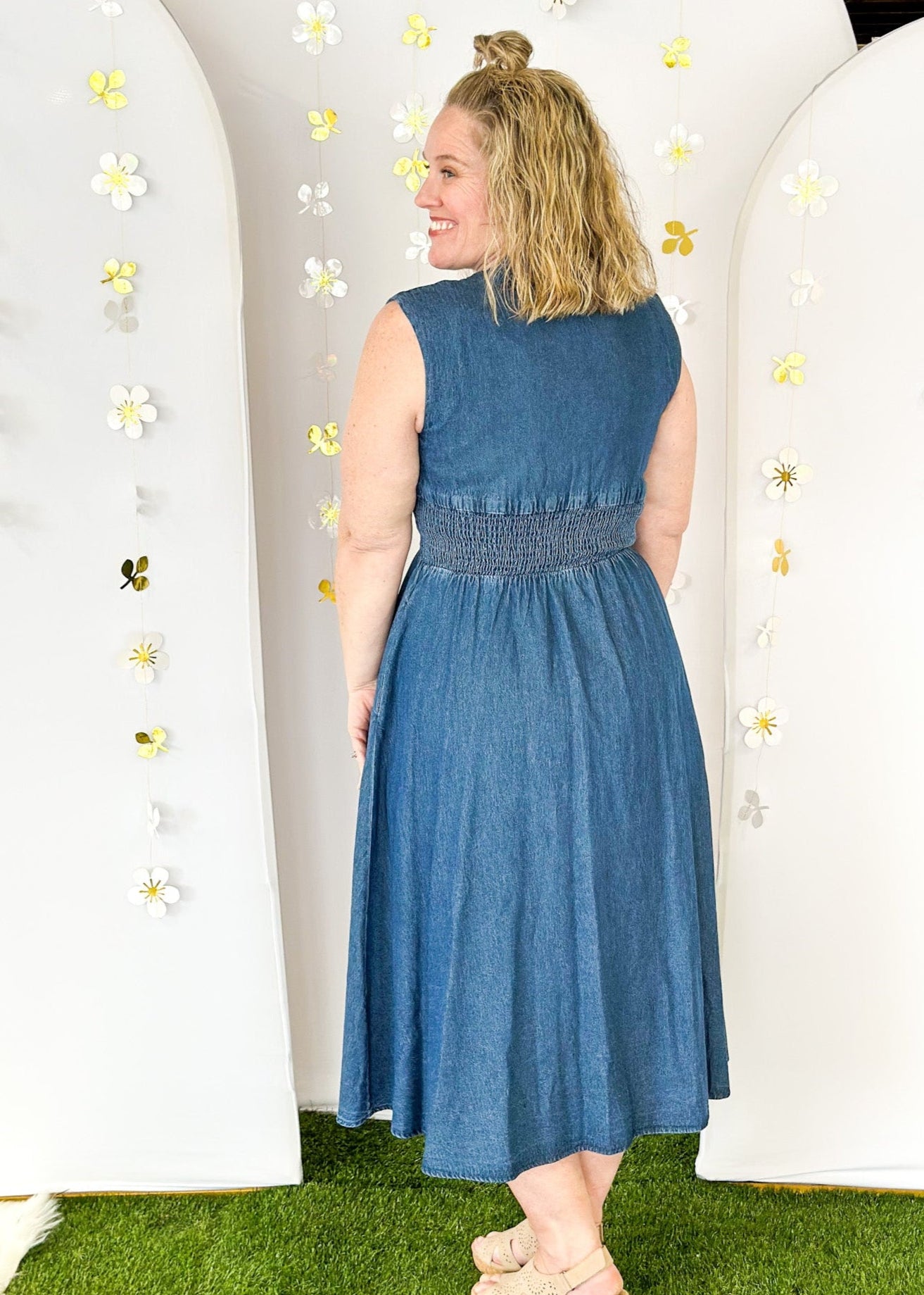 Sleeveless denim v-neck midi dress with cinched waist and pockets. Zipper closure down the front ending in a slit.  