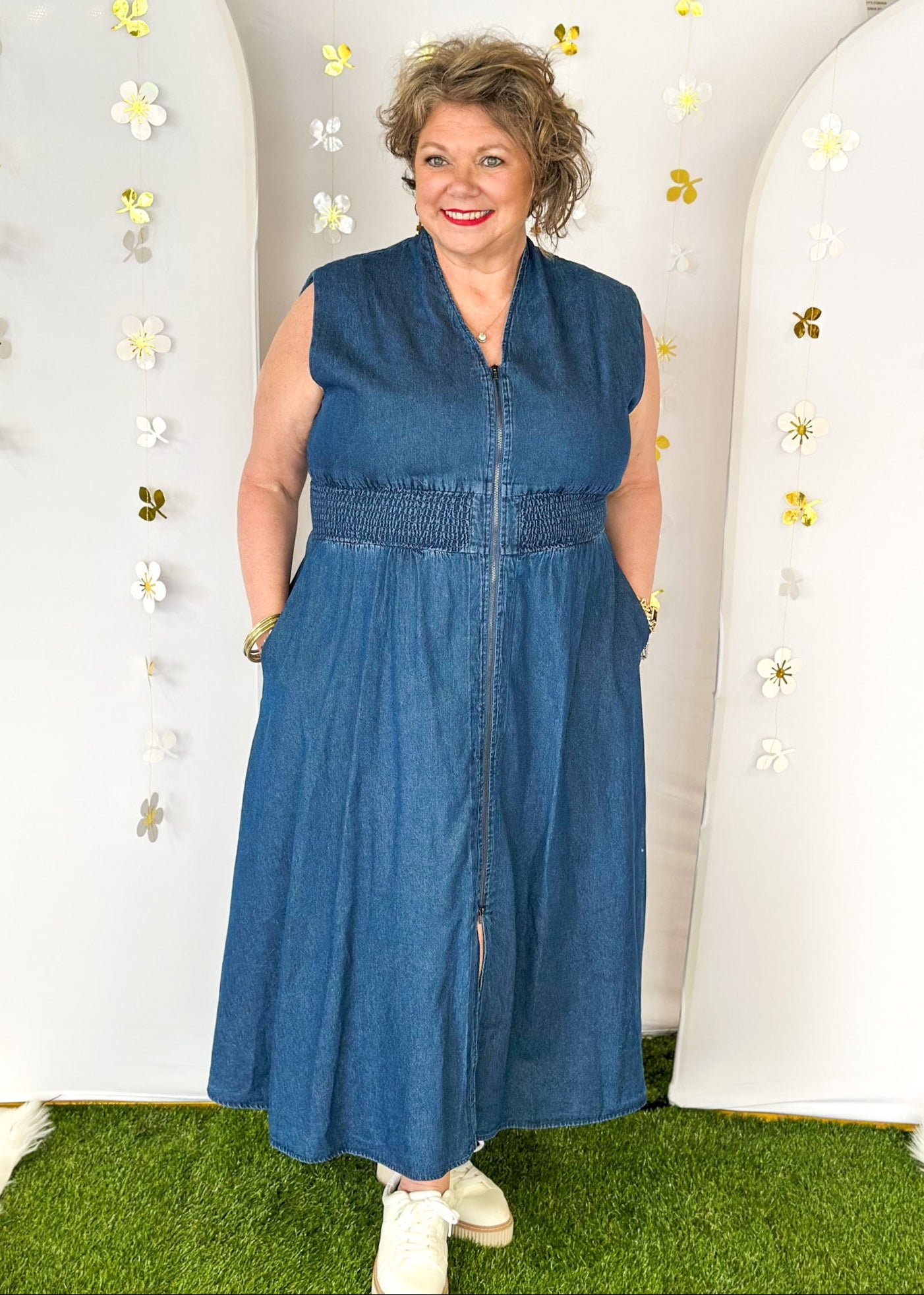 Sleeveless denim v-neck midi dress with cinched waist and pockets. Zipper closure down the front ending in a slit.  