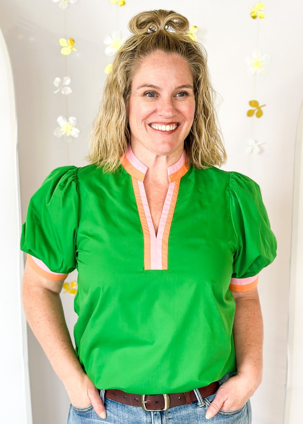 green v-neck short puff sleeve top with contrast striped banding around cuff and neck in pink and 