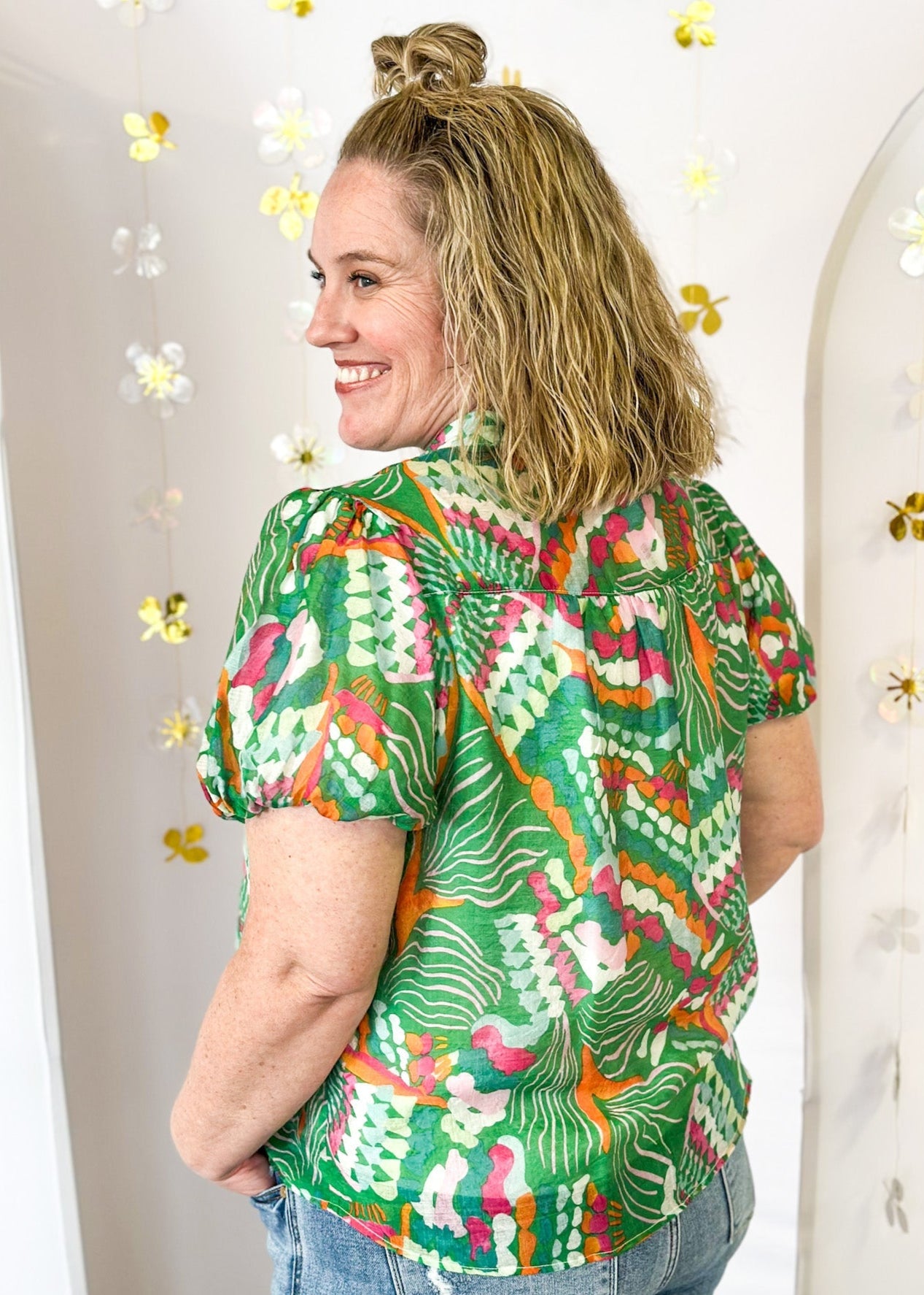 Lightweight short sleeve button up v-neck top.  Tropical print in green, white, pink and orange.  