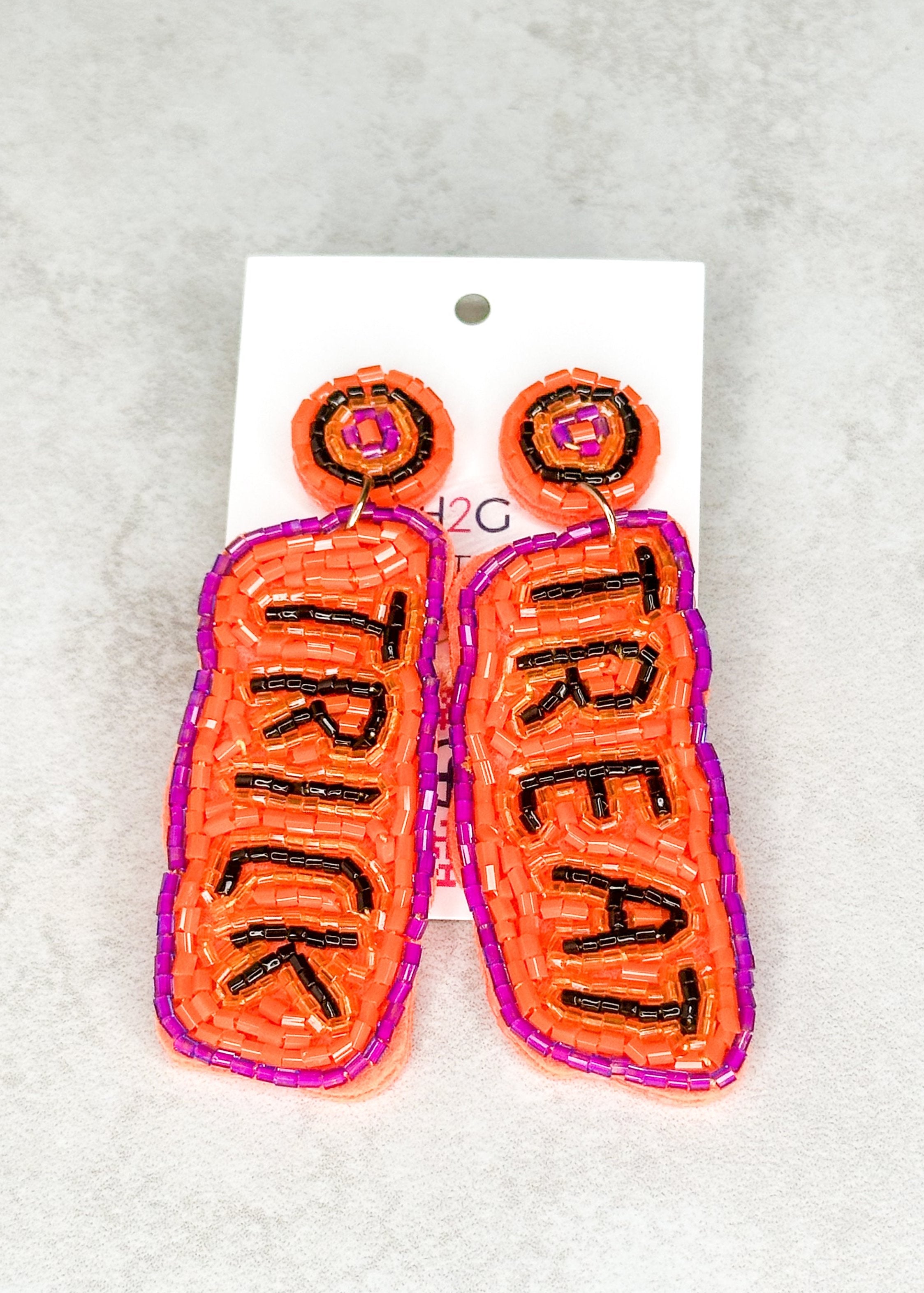 post back seed bead earrings - orange seed bead trimmed in purple - one earring spells trick and one spells treat in black beads