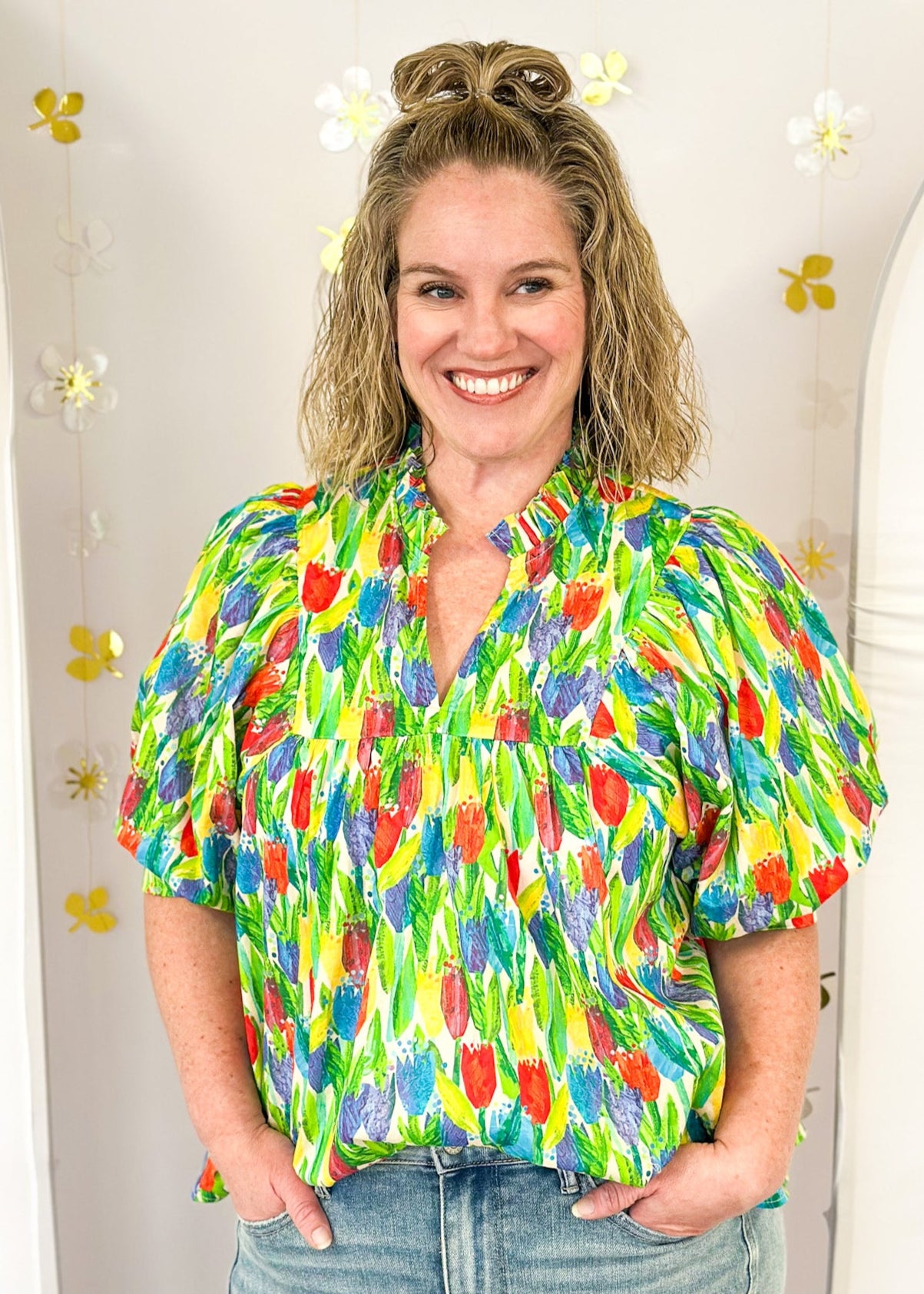 bright tulip print on oversized v-neck short dolman sleeve top w/banded cuff, ruffle around neckline, green leaves, tulips in red, blue purple and yellow