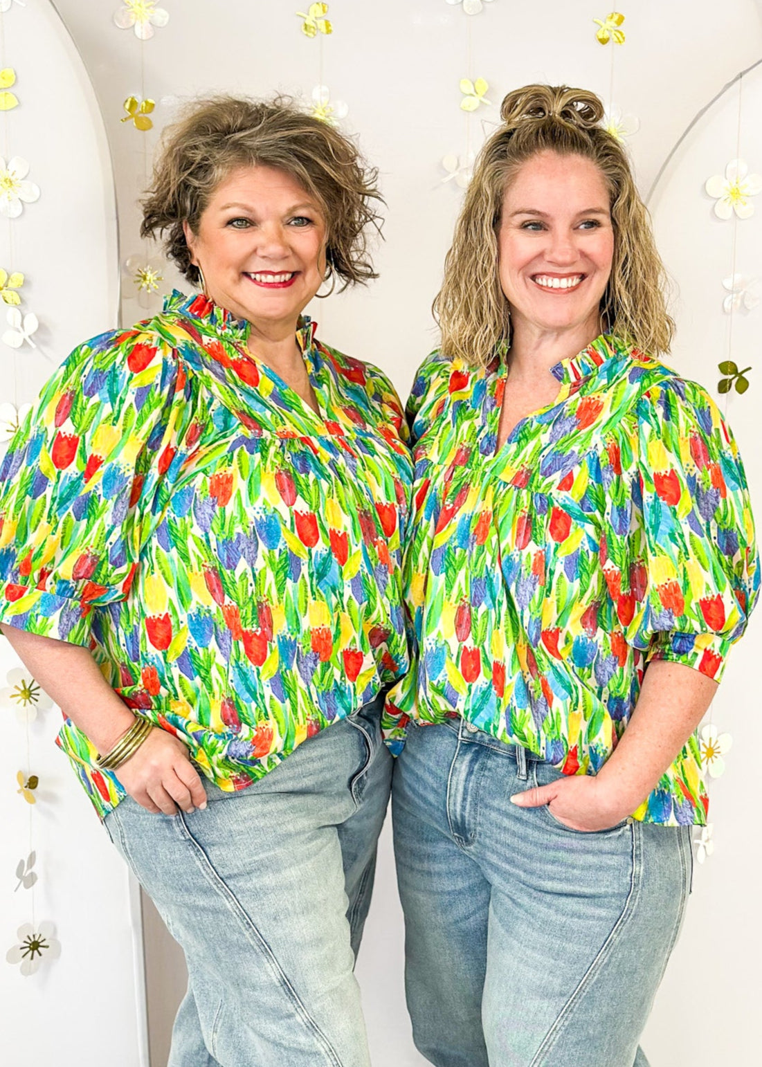 bright tulip print on oversized v-neck short dolman sleeve top w/banded cuff, ruffle around neckline, green leaves, tulips in red, blue purple and yellow