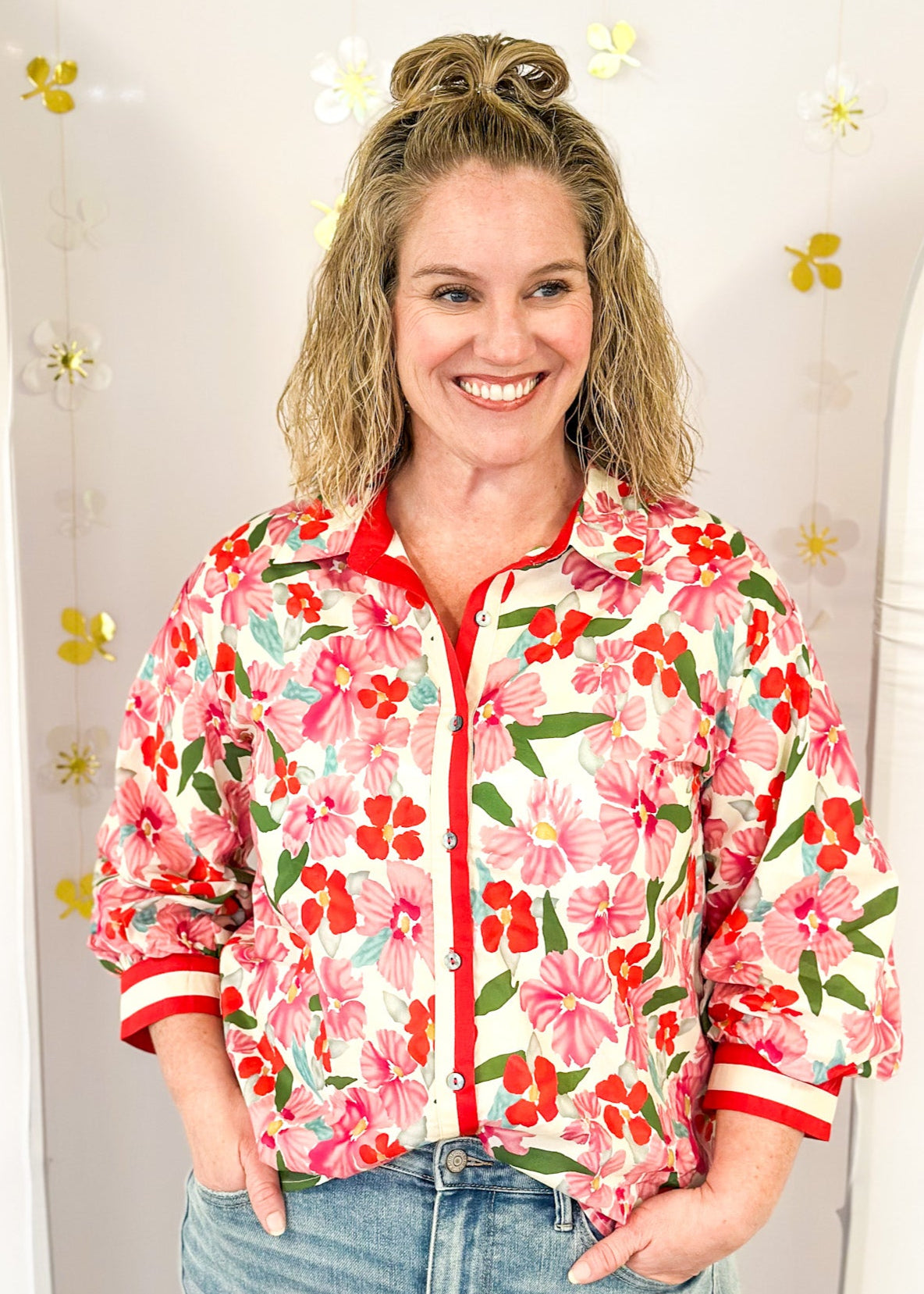 red and pink floral 3/4 sleeve top with cream and red stripe down the front and on cuff banding - cream background and green leaves, button up