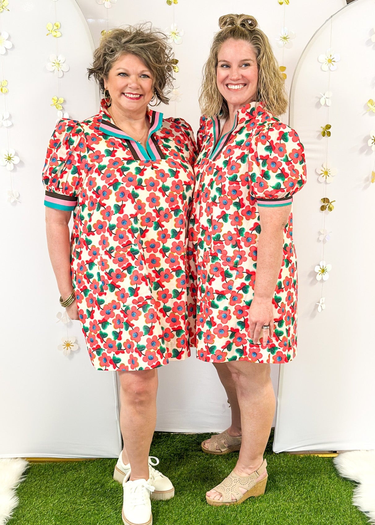 ream base v-neck dress with light red floral pattern.  Contrasting stripe sleeve and collar. Lined with pockets.